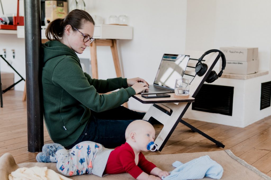  mother working from home - at flexible and height-adjustable desk with baby