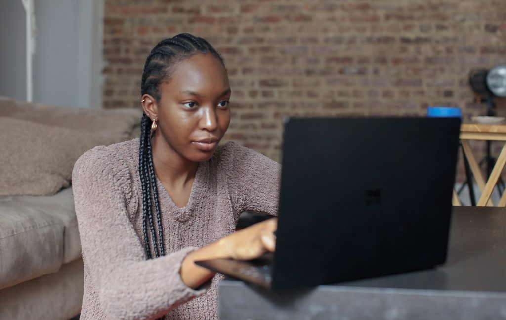 A woman works in her living room on a laptop