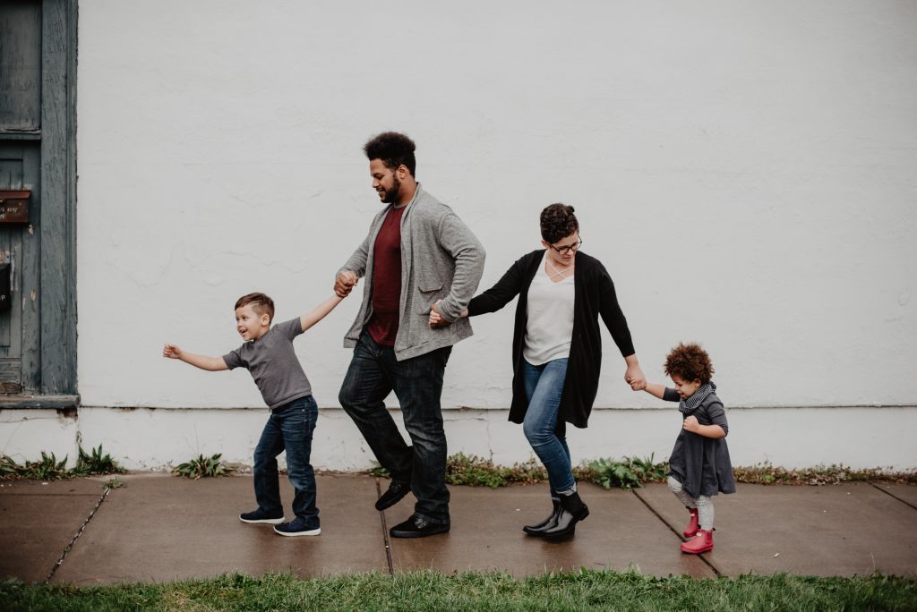 Multi-racial family holding hands